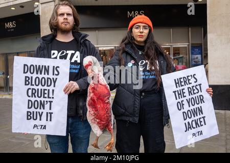 Londra, Regno Unito. 9 dicembre 2022. I sostenitori DI PETA che hanno un modello di un'oca morta e che trasportano segnali che si riferiscono alla campagna di giacche contro l'industria del piumino al di fuori della filiale ammiraglia di Marks & Spencer in Oxford Street. Secondo un'indagine PETA Asia, le piume di anatre sottoposte a crudeltà estrema sono state vendute a società come Marks & Spencer, H&M e Gap come "reperite in modo spontile". PETA sta chiedendo a Marks & Spencer e ad altre aziende di vietare la vendita di Down. Credit: Notizie dal vivo di Mark Kerrison/Alamy Foto Stock