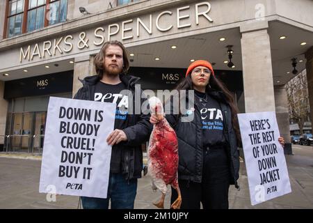 Londra, Regno Unito. 9 dicembre 2022. I sostenitori DI PETA che hanno un modello di un'oca morta e che trasportano segnali che si riferiscono alla campagna di giacche contro l'industria del piumino al di fuori della filiale ammiraglia di Marks & Spencer in Oxford Street. Secondo un'indagine PETA Asia, le piume di anatre sottoposte a crudeltà estrema sono state vendute a società come Marks & Spencer, H&M e Gap come "reperite in modo spontile". PETA sta chiedendo a Marks & Spencer e ad altre aziende di vietare la vendita di Down. Credit: Notizie dal vivo di Mark Kerrison/Alamy Foto Stock