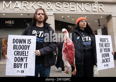 Londra, Regno Unito. 9 dicembre 2022. I sostenitori DI PETA che hanno un modello di un'oca morta e che trasportano segnali che si riferiscono alla campagna di giacche contro l'industria del piumino al di fuori della filiale ammiraglia di Marks & Spencer in Oxford Street. Secondo un'indagine PETA Asia, le piume di anatre sottoposte a crudeltà estrema sono state vendute a società come Marks & Spencer, H&M e Gap come "reperite in modo spontile". PETA sta chiedendo a Marks & Spencer e ad altre aziende di vietare la vendita di Down. Credit: Notizie dal vivo di Mark Kerrison/Alamy Foto Stock