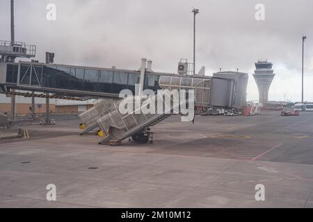 Accesso alla passerella per l'aeromobile e la sua torre di controllo in una giornata grigia e scura. Foto Stock