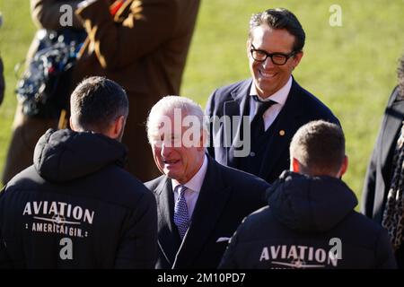 Ryan Reynolds guarda come re Carlo III parla con i giocatori all'ippodromo di Wrexham Association Football Club per conoscere la ristrutturazione del club, come parte della sua visita a Wrexham con la Regina Consort. Data immagine: Venerdì 9 dicembre 2022. Foto Stock