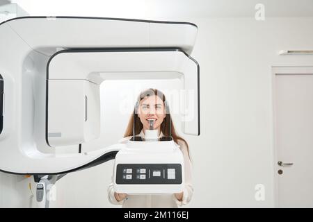 Paziente femmina che ha i denti scansionati con tomografo Foto Stock