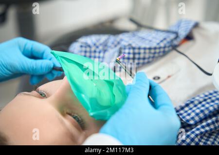 Coraggioso ragazzo si trova in una sedia presso il dentista Foto Stock