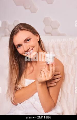 Trattamento di bellezza. donna tenere crema vaso in bagno. cura della pelle del viso e del corpo Foto Stock