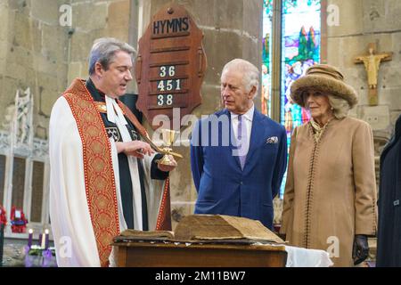 Re Carlo III e la Regina Consort sono mostrati una prima edizione King James Bible e un raro calice dei primi del 14th ° secolo dal Rev. Canon Dr Jason Bray dopo una celebrazione alla Chiesa di San Giles per contrassegnare Wrexham diventare una città. Data immagine: Venerdì 9 dicembre 2022. Foto Stock