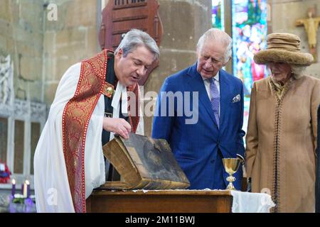 Re Carlo III e la Regina Consort sono mostrati una prima edizione King James Bible e un raro calice dei primi del 14th ° secolo dal Rev. Canon Dr Jason Bray dopo una celebrazione alla Chiesa di San Giles per contrassegnare Wrexham diventare una città. Data immagine: Venerdì 9 dicembre 2022. Foto Stock