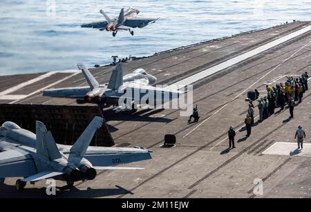 Filippine Mare, Stati Uniti. 09th Dec, 2022. NEGLI STATI UNITI Navy F/A-18E Super Hornet Fighter Aircraft attaccato ai maces reali di Strike Fighter Squadron 27, posizione per decollare dal ponte di volo durante le operazioni di lancio doppio fuori della portaerei di classe Nimitz USS Ronald Reagan, 9 dicembre 2022 che opera sul Mare delle Filippine. Credit: MC3 Eric Stanton/US Navy/Alamy Live News Foto Stock