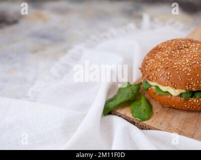 sandwich con prosciutto di formaggio e spinaci con fondo in cemento Foto Stock