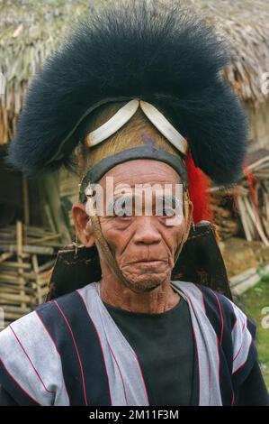 West Siang, Arunachal Pradesh, India - 02 22 2013 : Ritratto frontale all'aperto della tribù Adi Minyong, vecchio uomo che indossa una spettacolare headdress di guerra tradizionale Foto Stock