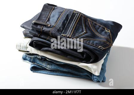 Un mucchio di jeans su sfondo bianco. Foto Stock