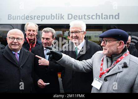 09 dicembre 2022, Baden-Wuerttemberg, Stoccarda: Michael Theurer (FDP l-r), commissario federale per i trasporti ferroviari, Wolfgang Schuster (CDU), ex sindaco di Stoccarda, Günther Oettinger (CDU), ex ministro presidente del Baden-Württemberg, Winfried Kretschmann (Bündnis 90/Die Grünen), ministro presidente del Baden-Württemberg, E Winfried Hermann (Bündnis 90/Die Grünen), ministro dei Trasporti di Baden-Württemberg, si trovano su una piattaforma presso la stazione centrale di Stoccarda durante il viaggio speciale per celebrare l'apertura della nuova linea ferroviaria Wendlingen-Ulm. Uno speciale treno ICE wi Foto Stock