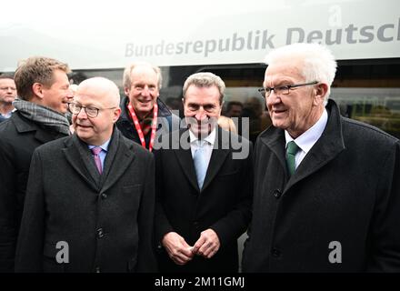 09 dicembre 2022, Baden-Wuerttemberg, Stoccarda: Richard Lutz (da sinistra), presidente del consiglio di amministrazione della Deutsche Bahn AG, Michael Theurer (FDP), commissario federale per i trasporti ferroviari, Wolfgang Schuster (CDU), ex sindaco di Stoccarda, Günther Oettinger (CDU), ex ministro del Baden-Württemberg, E Winfried Kretschmann (Bündnis 90/Die Grünen), Ministro Presidente del Baden-Württemberg, si trovano su una piattaforma nella stazione centrale di Stoccarda durante il viaggio speciale per celebrare l'apertura della nuova linea ferroviaria Wendlingen-Ulm. Un treno SPECIALE SU GHIACCIO con i gues invitati Foto Stock