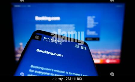 Telefono cellulare con sito web della società di tecnologia di viaggio Booking Holdings Inc. (Booking.com) sullo schermo. Messa a fuoco in alto a sinistra del display del telefono. Foto Stock