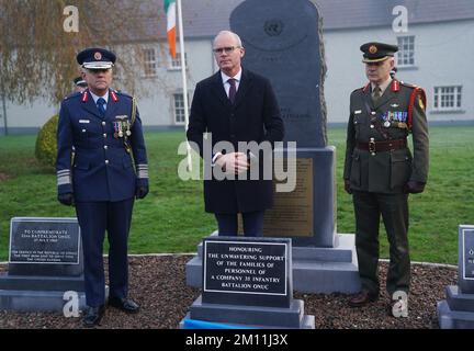 Il ministro della Difesa Simon Coveney (centro) accompagnato dal tenente generale Sean Clancy (sinistra), capo di stato maggiore delle forze di difesa, E il generale brigadiere Tony Cudmore, durante un evento per svelare un monumento dedicato alle famiglie del personale di Una Compagnia, 35th Battaglione di Fanteria che ha partecipato all'assedio di Jadotville nel settembre 1961, presso la Caserma Custume, Athlone. Data immagine: Venerdì 9 dicembre 2022. Foto Stock