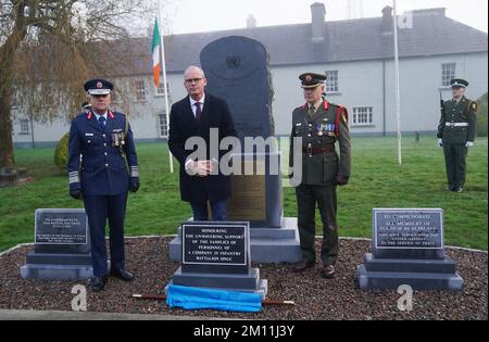 Il ministro della Difesa Simon Coveney (centro) accompagnato dal tenente generale Sean Clancy (sinistra), capo di stato maggiore delle forze di difesa, E il generale brigadiere Tony Cudmore, durante un evento per svelare un monumento dedicato alle famiglie del personale di Una Compagnia, 35th Battaglione di Fanteria che ha partecipato all'assedio di Jadotville nel settembre 1961, presso la Caserma Custume, Athlone. Data immagine: Venerdì 9 dicembre 2022. Foto Stock