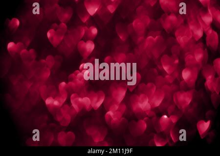 Trendy viva magenta colore dell'anno 2023, cuori rossi rosa, sfondo bokeh brillante glitter, giorno di San Valentino astratto tessuto sfocato Foto Stock