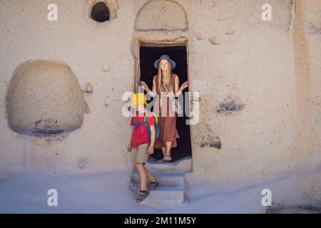 Mamma e figlio turisti esplorando la valle con formazioni rocciose e grotte delle fate vicino a Goreme in Cappadocia Turchia Foto Stock