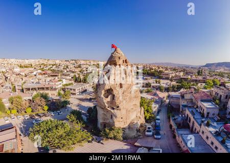 Bandiera turca sulla collina con tipiche formazioni rocciose di tufo della Cappadocia sullo sfondo di un cielo blu, Goreme, Turchia Foto Stock