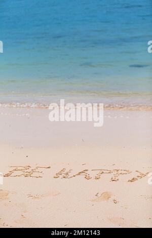 Siate felici - come un messaggio scritto con un dito nella sabbia su una spiaggia con le onde e l'oceano blu a Mauritius Island, Africa, vista dall'alto, nessuno Foto Stock