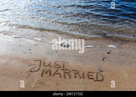 MESSAGGIO APPENA SPOSATO scritto con un dito nella sabbia su una spiaggia con le onde e l'oceano blu a Mauritius Island, Africa, vista dall'alto, nessuno Foto Stock