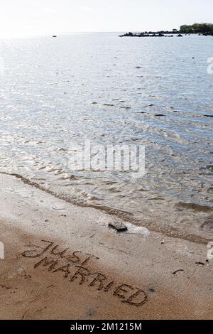 MESSAGGIO APPENA SPOSATO scritto con un dito nella sabbia su una spiaggia con le onde e l'oceano blu a Mauritius Island, Africa, vista dall'alto, nessuno Foto Stock
