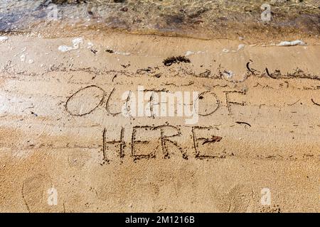 Fuori di qui - come un messaggio scritto con un dito nella sabbia su una spiaggia con le onde e l'oceano blu a Mauritius Island, Africa, vista dall'alto, nessuno Foto Stock