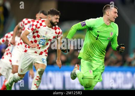 Il portiere della Croazia Dominik Livakovic (a destra) festeggia con i compagni di squadra dopo la vittoria nel calcio di punizione dopo il tempo extra nella partita di Quarter-Final della Coppa del mondo FIFA presso l'Education City Stadium di al Rayyan, Qatar. Data immagine: Venerdì 9 dicembre 2022. Foto Stock