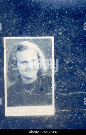 Vecchia foto di una giovane donna dietro un vetro sporco Foto Stock
