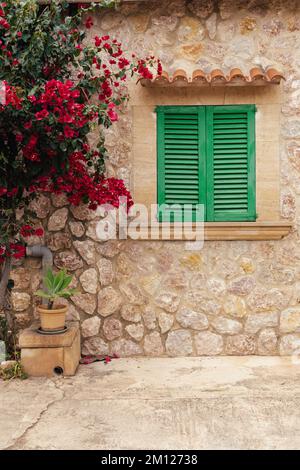 Facciata casa mediterranea con bougainvillea rossa a Maiorca, Spagna Foto Stock