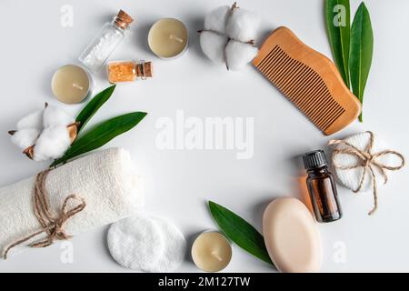 Set di cosmetici naturali e accessori spa su sfondo bianco. Asciugamano, sapone, spazzola per capelli, olio essenziale. Concetto di cura del viso e del corpo. Trattamenti di bellezza Foto Stock