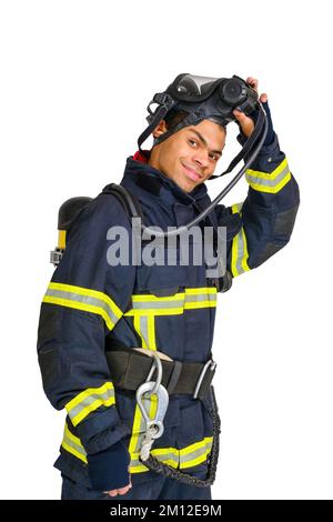 Pompiere in uniforme e con respiratore d'aria toglie la maschera protettiva Foto Stock