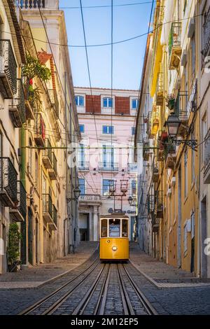 Storico tram giallo in una strada ripida a Lisbona, Portogallo Foto Stock