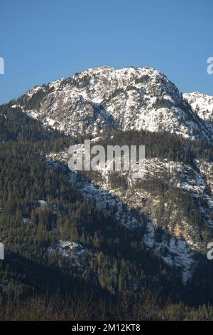 La catena montuosa innevata del Tantalo si vede dalla diga Eagle Run di Brackendale, Squamish, British Columbia, Canada Foto Stock