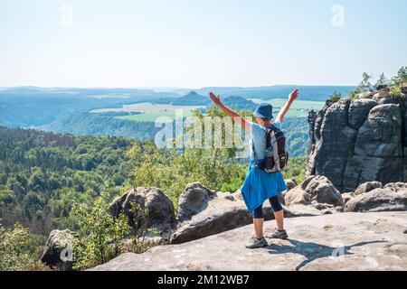 Donna anziana che si arrampica sulle montagne di arenaria dell'Elba in estate, Svizzera sassone Foto Stock