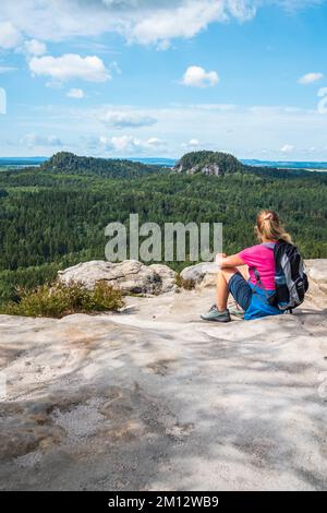 Donna anziana che si arrampica sulle montagne di arenaria dell'Elba in estate, Svizzera sassone Foto Stock