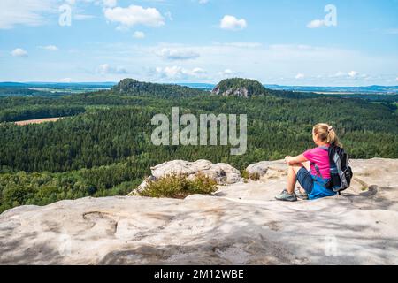 Donna anziana che si arrampica sulle montagne di arenaria dell'Elba in estate, Svizzera sassone Foto Stock