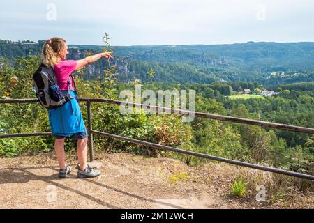 Donna anziana che si arrampica sulle montagne di arenaria dell'Elba in estate, Svizzera sassone Foto Stock