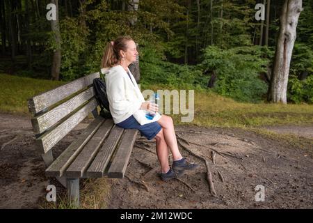 Donna anziana che cammina nel Parco Nazionale di Jasmund in autunno, Meclemburgo-Pomerania occidentale Foto Stock