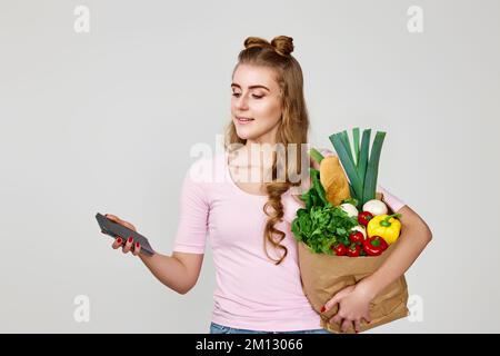 donna in possesso di shopping eco-friendly sacchetto di carta pieno di generi alimentari Foto Stock