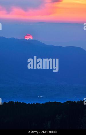 Sole rosso sangue sulle Alpi Bernesi al tramonto, Canton Berna, Svizzera, Europa Foto Stock