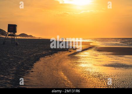 Atmosfera serale sulla spiaggia del Mare del Nord con la bassa marea, in lontananza due persone si sono stagliate Foto Stock