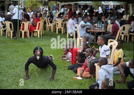 KENYA, Nairobi, classe media in birreria all'aperto, spettacolo acrobatico / KENIA, Nairobi, Mittelklasse im Biergarten, akrobatische Vorführung zur Unterhaltung der Gäste Foto Stock