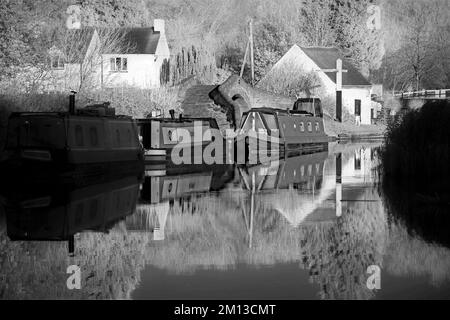 Fotografia in bianco e nero di tonalità seppia delle barche a remi sui corsi d'acqua a Haywood Junction Staffordshire, tono di seppia che porta un loo datato e nostalgico Foto Stock