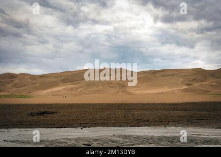 Vicino a Buck Creek, i visitatori iniziano la loro escursione in salita al Great Sand Dunes National Park in Colorado. Foto Stock