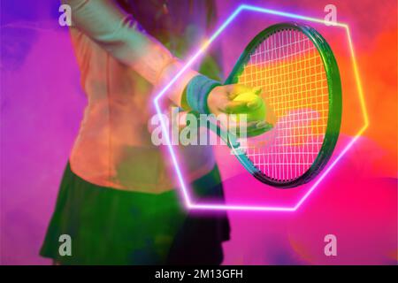 Sezione centrale di una tennista afro-americana che serve palla con racchetta da esagono illuminato Foto Stock