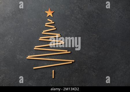 Albero di Natale creativo realizzato con cannucce di carta per cocktail su sfondo scuro con spazio copia Foto Stock