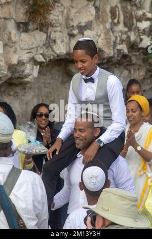 10 Nov 2022 Un giovane uomo ha alzato la spalla in alto mentre la famiglia e gli amici godono le sue celebrazioni Bar Mitzvah vicino alla porta di Jaffa mentre la festa fa il relativo senso t Foto Stock