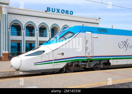 KAGAN, UZBEKISTAN - 11 SETTEMBRE 2022: Locomotiva del treno ad alta velocità Talgo 250 'Afrosiyob' primo piano sullo sfondo dell'edificio della stazione Foto Stock