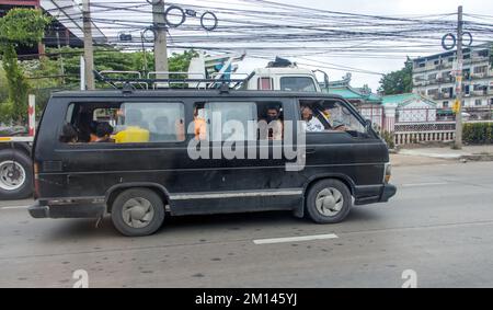 SAMUT PRAKAN, THAILANDIA, 21 2022 MAGGIO, Un minivan guida lungo la strada con persone all'interno Foto Stock