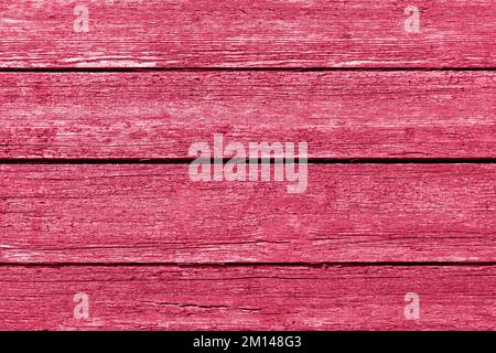 Sfondo in legno vintage con vernice rosso peeling. Trendy Viva Magenta colore dell'anno 2023 Foto Stock